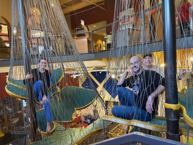 three people in a climbing canopy at WonderLab